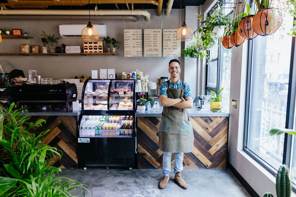 A member of the cafe team standing by the coffee counter